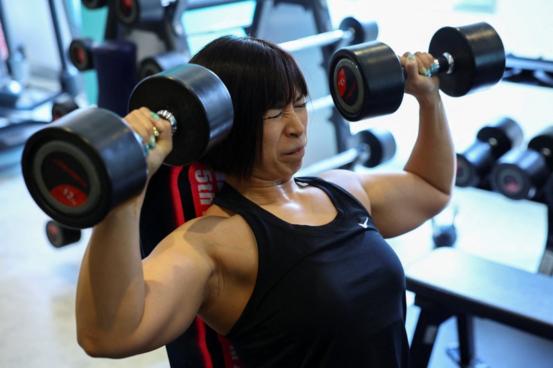 Hitomi Harigae, 38 tahun, manajer Muscle Girls, sebuah bar bertema kebugaran, memamerkan otot-ototnya saat pertunjukan tari di Tokyo, Jepang, 25 Juli 2025. 