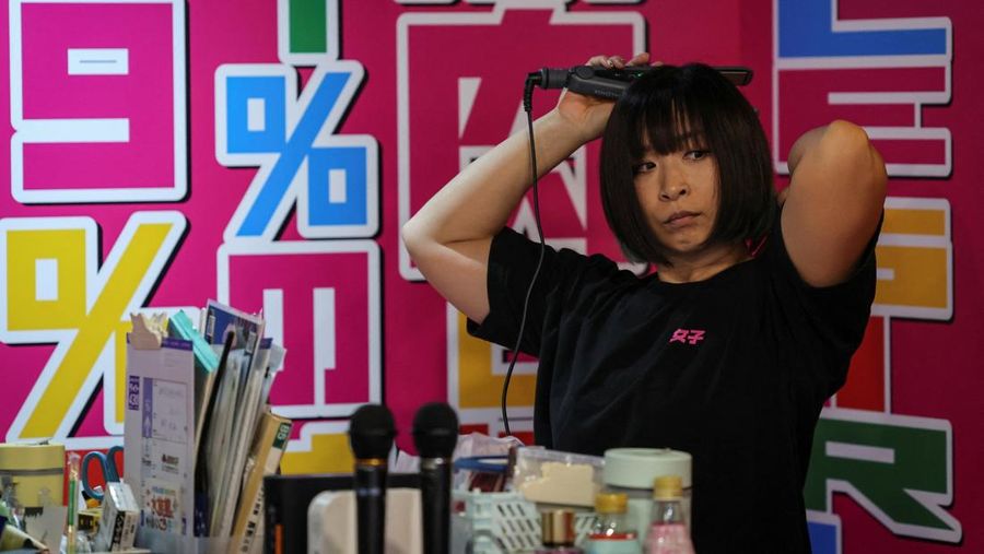 Hitomi Harigae, 38 tahun, manajer Muscle Girls, sebuah bar bertema kebugaran, memamerkan otot-ototnya saat pertunjukan tari di Tokyo, Jepang, 25 Juli 2025. 