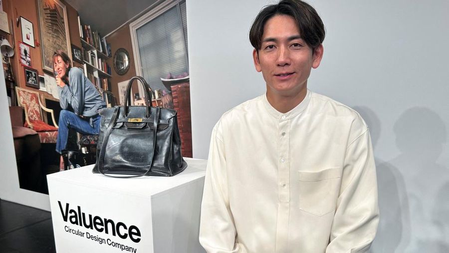 Shinsuke Sakimoto, CEO Valuence Japan, berpose untuk foto di sebelah Birkin Original, tas asli yang dibuat khusus untuk mendiang aktris Jane Birkin, yang dibeli perusahaan Jepang tersebut dengan rekor 8,6 juta euro ($10,04 juta) pada lelang Sotheby's di Paris awal tahun ini, selama acara peluncuran di Tokyo, Jepang, 12 November 2025. (REUTERS/Joseph Campbell)