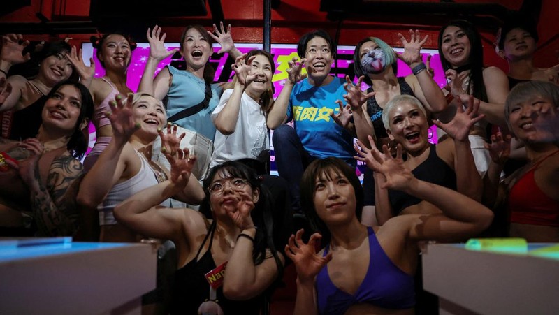 Hitomi Harigae, 38 tahun, manajer Muscle Girls, sebuah bar bertema kebugaran, memamerkan otot-ototnya saat pertunjukan tari di Tokyo, Jepang, 25 Juli 2025. 