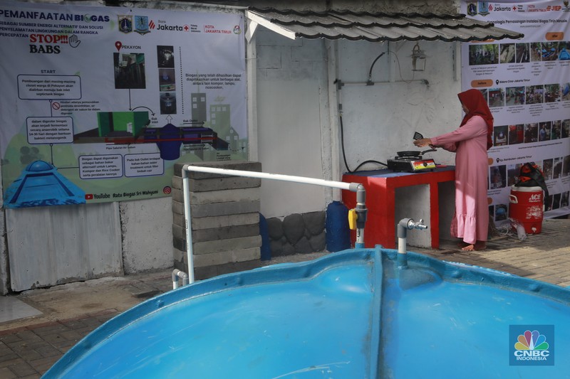 Warga memasak menggunakan kompor biogas melalui instalasi tangki septik komunal di permukiman Gang Delta, Pekayon, Pasar Rebo, Jakarta Timur, Kamis (13/11/2025). (CNBC Indonesia/Muhamad Sabki)