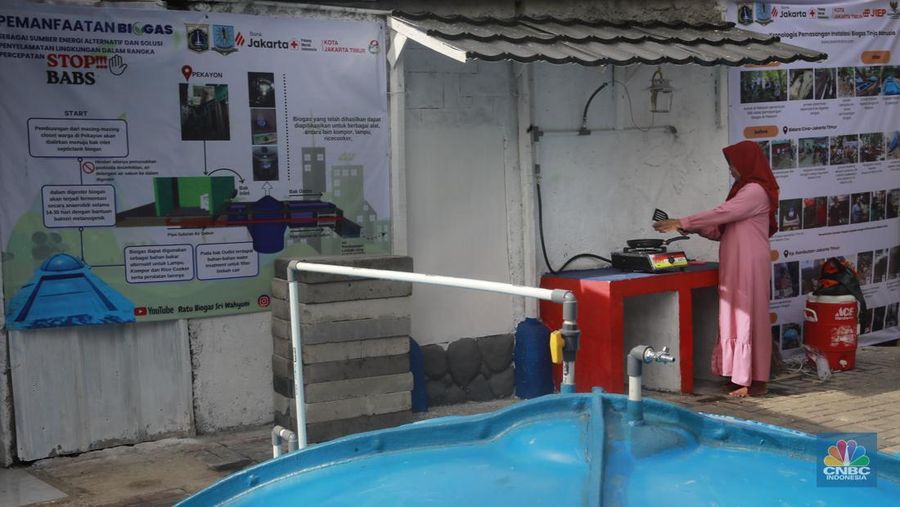 Warga memasak menggunakan kompor biogas melalui instalasi tangki septik komunal di permukiman Gang Delta, Pekayon, Pasar Rebo, Jakarta Timur, Kamis (13/11/2025). (CNBC Indonesia/Muhamad Sabki)