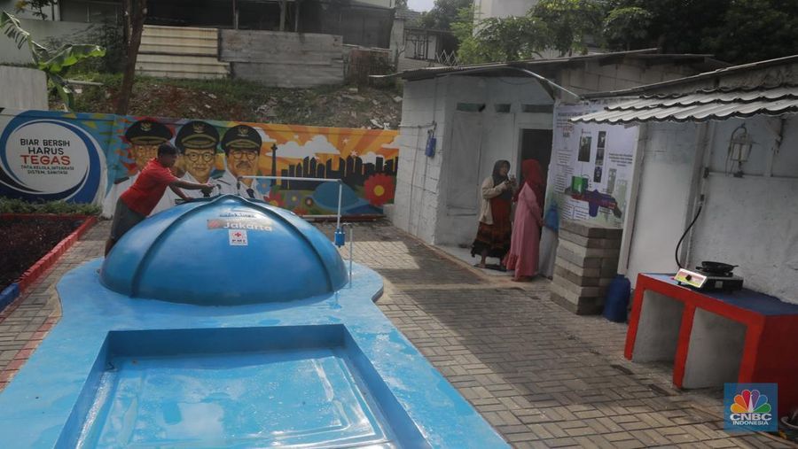 Warga memasak menggunakan kompor biogas melalui instalasi tangki septik komunal di permukiman Gang Delta, Pekayon, Pasar Rebo, Jakarta Timur, Kamis (13/11/2025). (CNBC Indonesia/Muhamad Sabki)