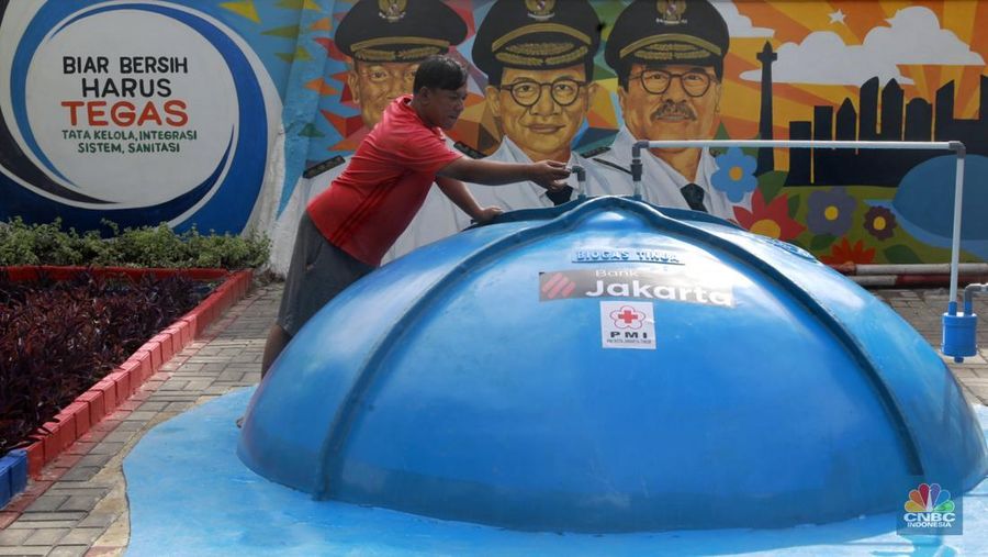 Warga memasak menggunakan kompor biogas melalui instalasi tangki septik komunal di permukiman Gang Delta, Pekayon, Pasar Rebo, Jakarta Timur, Kamis (13/11/2025). (CNBC Indonesia/Muhamad Sabki)