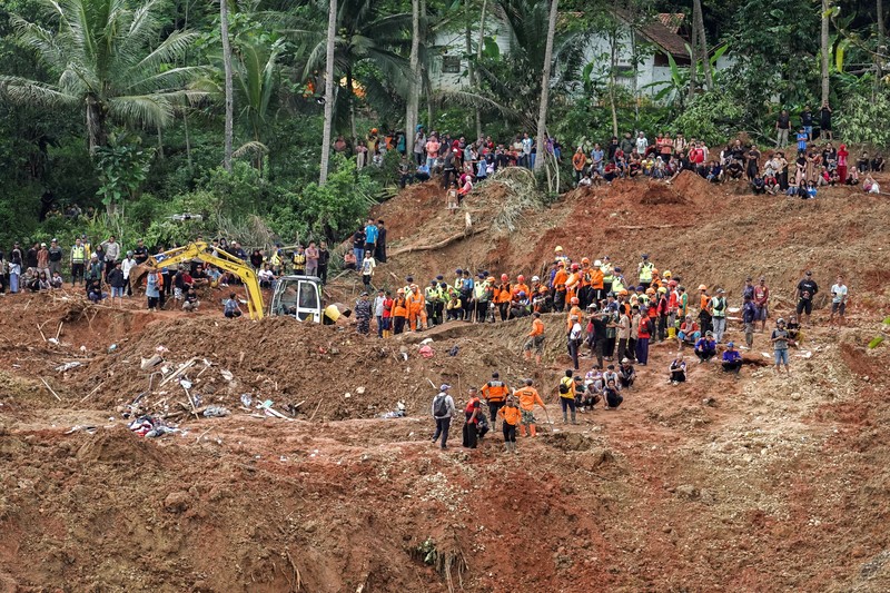 Anggota Badan SAR Nasional melakukan pencarian korban dari lokasi longsor yang melanda Desa Cibeunying di Cilacap, Jawa Tengah, Sabtu (15/11/2025). (REUTERS/Stringer)