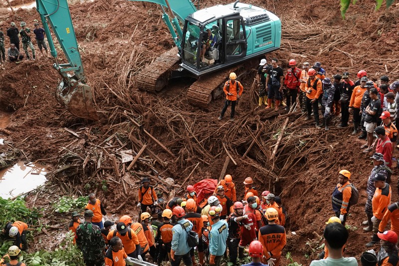 Anggota Badan SAR Nasional melakukan pencarian korban dari lokasi longsor yang melanda Desa Cibeunying di Cilacap, Jawa Tengah, Sabtu (15/11/2025). (REUTERS/Stringer)
