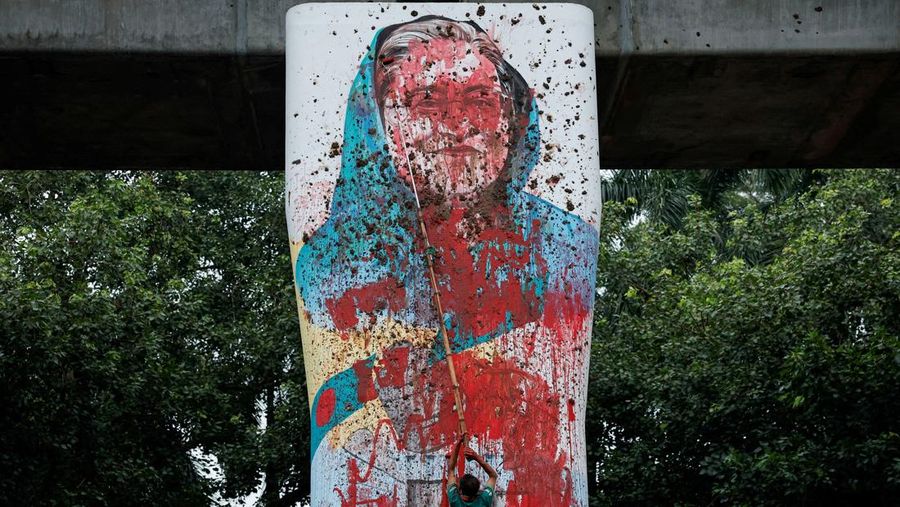 Seorang pria memegang poster di depan pengadilan yang menuntut hukuman mati menjelang putusan atas tuduhan kejahatan terhadap kemanusiaan atas tindakan keras mematikan terhadap protes mahasiswa pada tahun 2024 terhadap Perdana Menteri terguling Sheikh Hasina, di Dhaka, Bangladesh, 17 November 2025. REUTERS/Mohammad Ponir Hossain