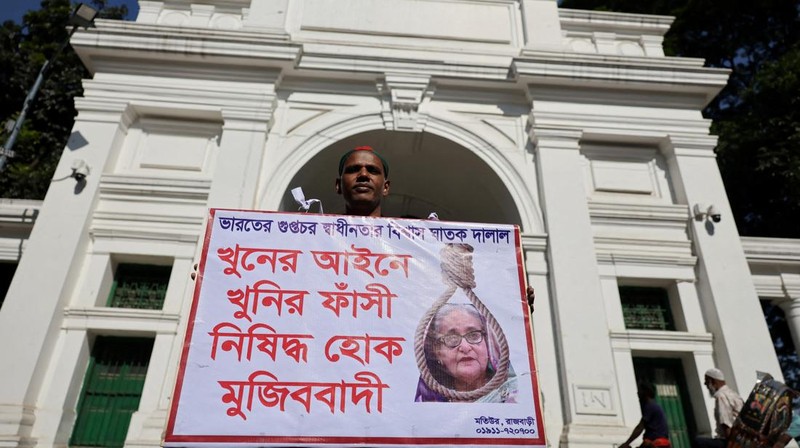 Seorang pria memegang poster di depan pengadilan yang menuntut hukuman mati menjelang putusan atas tuduhan kejahatan terhadap kemanusiaan atas tindakan keras mematikan terhadap protes mahasiswa pada tahun 2024 terhadap Perdana Menteri terguling Sheikh Hasina, di Dhaka, Bangladesh, 17 November 2025. REUTERS/Mohammad Ponir Hossain