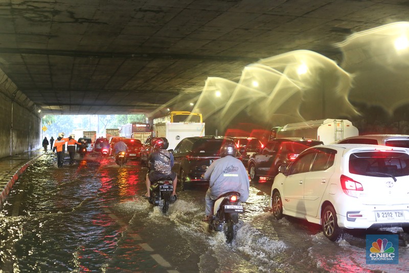 Sejumlah kendaraan melewati genangan di depan kantor Kementerian Pertahanan atau tepatnya di terowongan Halim Lama arah UKI Cawang atau Terowongan Cawang, Jakarta Timur, Selasa (18/11/2025). (CNBC Indonesia/Tias Budiarto)