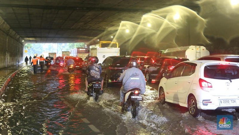 Sejumlah kendaraan melewati genangan di depan kantor Kementerian Pertahanan atau tepatnya di terowongan Halim Lama arah UKI Cawang atau Terowongan Cawang, Jakarta Timur, Selasa (18/11/2025). (CNBC Indonesia/Tias Budiarto)