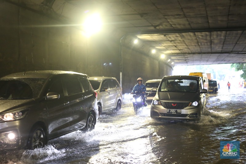 Sejumlah kendaraan melewati genangan di depan kantor Kementerian Pertahanan atau tepatnya di terowongan Halim Lama arah UKI Cawang atau Terowongan Cawang, Jakarta Timur, Selasa (18/11/2025). (CNBC Indonesia/Tias Budiarto)
