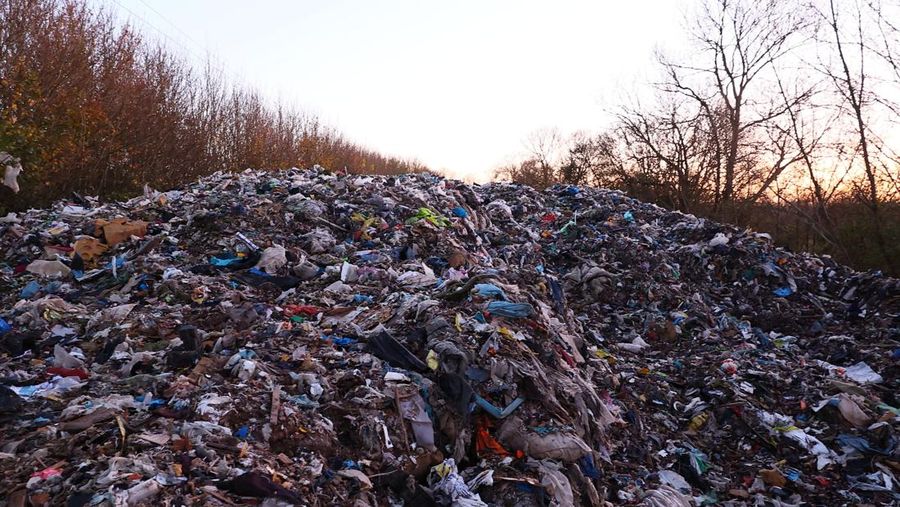 Seorang pria berjalan melewati tumpukan sampah yang dibuang secara ilegal di dataran banjir di sebelah jalan A34, yang memicu penyelidikan Badan Lingkungan Hidup terhadap dugaan kejahatan terorganisir, dekat Kidlington, Oxfordshire, Inggris, 17 November 2025. (REUTERS/Isabel Infantes)