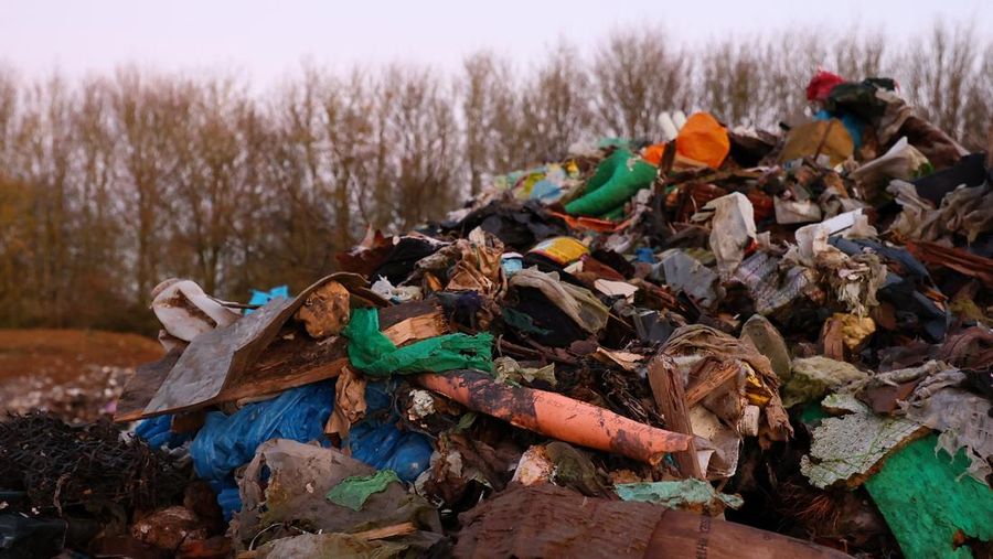 Seorang pria berjalan melewati tumpukan sampah yang dibuang secara ilegal di dataran banjir di sebelah jalan A34, yang memicu penyelidikan Badan Lingkungan Hidup terhadap dugaan kejahatan terorganisir, dekat Kidlington, Oxfordshire, Inggris, 17 November 2025. (REUTERS/Isabel Infantes)