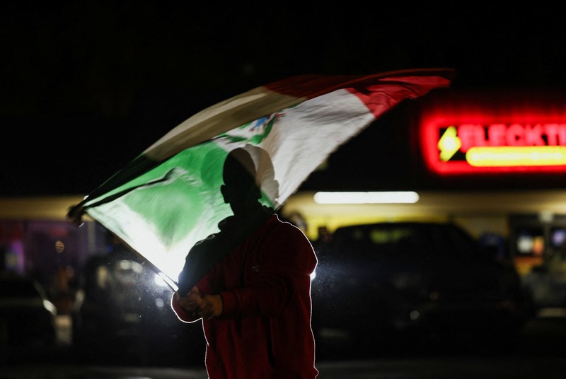 A demonstrator waves a Mexican flag from inside a moving car as people take part in a protest, after federal authorities conducted raids, expanding their crackdown on illegal immigration, in Charlotte, North Carolina, U.S., November 17, 2025.  REUTERS/Sam Wolfe