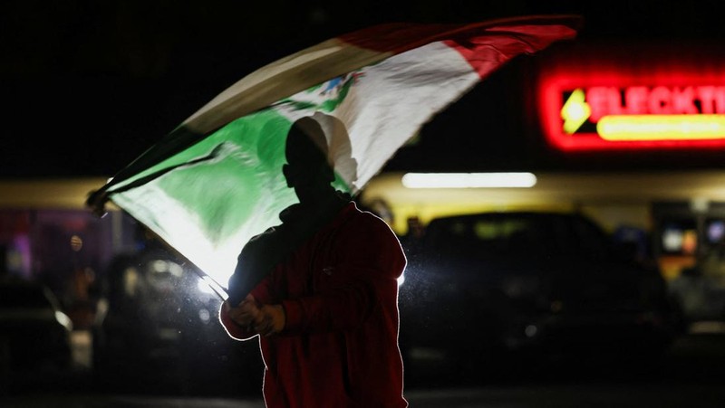 A demonstrator waves a Mexican flag from inside a moving car as people take part in a protest, after federal authorities conducted raids, expanding their crackdown on illegal immigration, in Charlotte, North Carolina, U.S., November 17, 2025.  REUTERS/Sam Wolfe