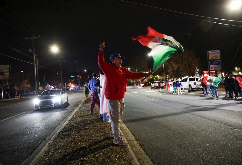A demonstrator waves a Mexican flag from inside a moving car as people take part in a protest, after federal authorities conducted raids, expanding their crackdown on illegal immigration, in Charlotte, North Carolina, U.S., November 17, 2025.  REUTERS/Sam Wolfe