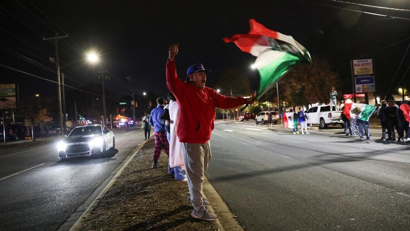 A demonstrator waves a Mexican flag from inside a moving car as people take part in a protest, after federal authorities conducted raids, expanding their crackdown on illegal immigration, in Charlotte, North Carolina, U.S., November 17, 2025.  REUTERS/Sam Wolfe