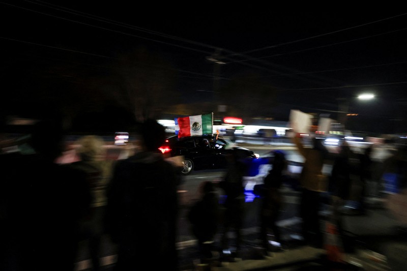 A demonstrator waves a Mexican flag from inside a moving car as people take part in a protest, after federal authorities conducted raids, expanding their crackdown on illegal immigration, in Charlotte, North Carolina, U.S., November 17, 2025.  REUTERS/Sam Wolfe