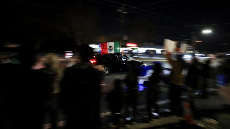 A demonstrator waves a Mexican flag from inside a moving car as people take part in a protest, after federal authorities conducted raids, expanding their crackdown on illegal immigration, in Charlotte, North Carolina, U.S., November 17, 2025.  REUTERS/Sam Wolfe