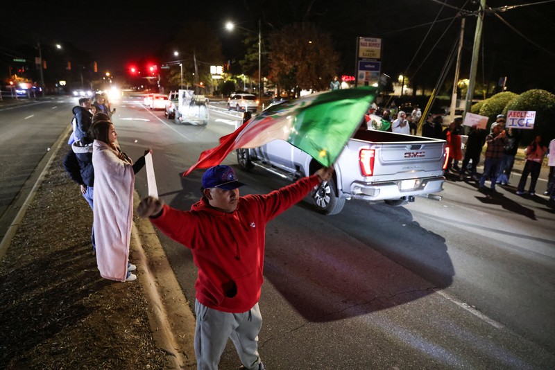 A demonstrator waves a Mexican flag from inside a moving car as people take part in a protest, after federal authorities conducted raids, expanding their crackdown on illegal immigration, in Charlotte, North Carolina, U.S., November 17, 2025.  REUTERS/Sam Wolfe