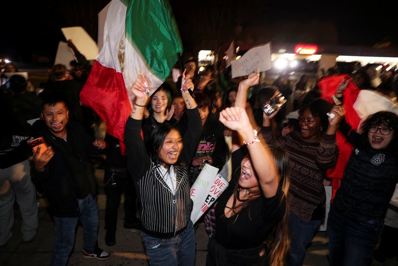 A demonstrator waves a Mexican flag from inside a moving car as people take part in a protest, after federal authorities conducted raids, expanding their crackdown on illegal immigration, in Charlotte, North Carolina, U.S., November 17, 2025.  REUTERS/Sam Wolfe