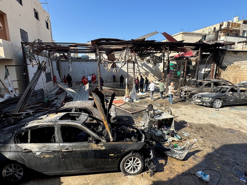 Masyarakat dan paramedis berkumpul di lokasi serangan Israel yang menewaskan beberapa orang kemarin malam, menurut Kementerian Kesehatan Lebanon, di dalam kamp pengungsi Palestina Ain al-Hilweh di kota selatan Sidon, Lebanon, 19 November 2025. (REUTERS/Ali Hankir)