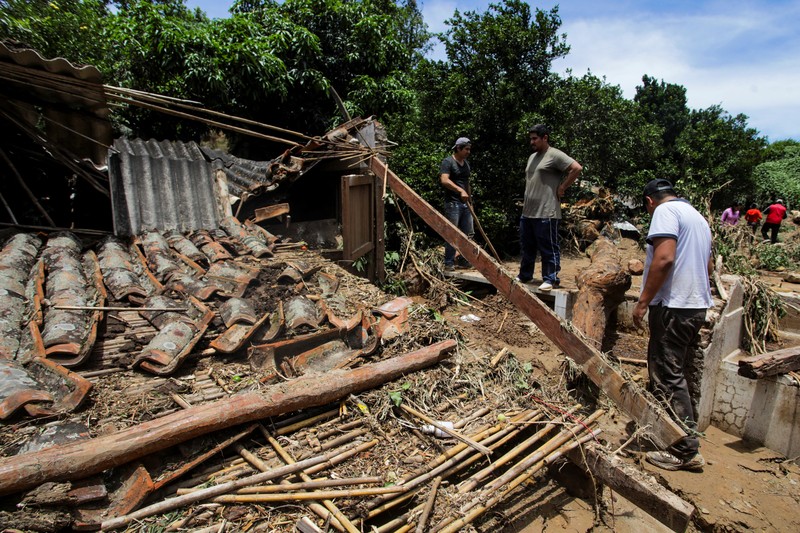 Seorang anak duduk di luar rumah yang rusak akibat tanah longsor setelah enam jam hujan deras yang menghancurkan rumah-rumah dan menyebabkan orang hilang, di Achira, Santa Cruz, Bolivia, 18 November 2025. (REUTERS/Ipa Ibanez)