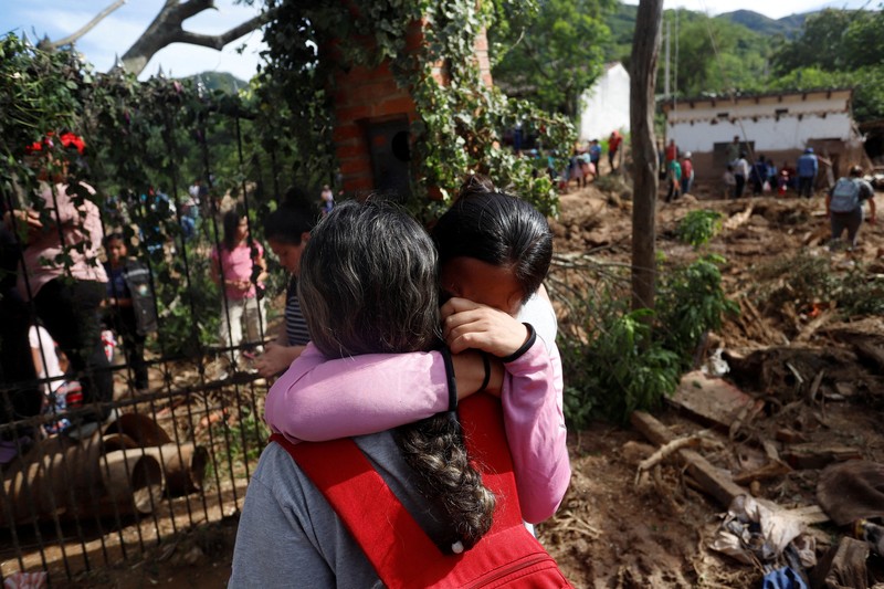 Seorang anak duduk di luar rumah yang rusak akibat tanah longsor setelah enam jam hujan deras yang menghancurkan rumah-rumah dan menyebabkan orang hilang, di Achira, Santa Cruz, Bolivia, 18 November 2025. (REUTERS/Ipa Ibanez)