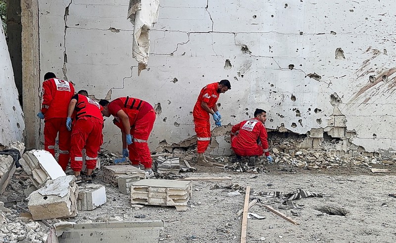 Masyarakat dan paramedis berkumpul di lokasi serangan Israel yang menewaskan beberapa orang kemarin malam, menurut Kementerian Kesehatan Lebanon, di dalam kamp pengungsi Palestina Ain al-Hilweh di kota selatan Sidon, Lebanon, 19 November 2025. (REUTERS/Ali Hankir)