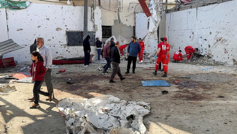 Masyarakat dan paramedis berkumpul di lokasi serangan Israel yang menewaskan beberapa orang kemarin malam, menurut Kementerian Kesehatan Lebanon, di dalam kamp pengungsi Palestina Ain al-Hilweh di kota selatan Sidon, Lebanon, 19 November 2025. (REUTERS/Ali Hankir)