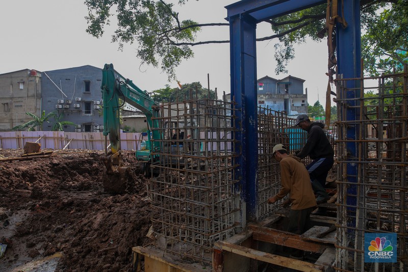 Pekerja mengerjakan proyek pembangunan tanggul dan pintu air Kali Krukut di kawasan Cilandak Timur, Jakarta, Rabu (19/11/2025).  (CNBC Indonesia/Faisal Rahman)