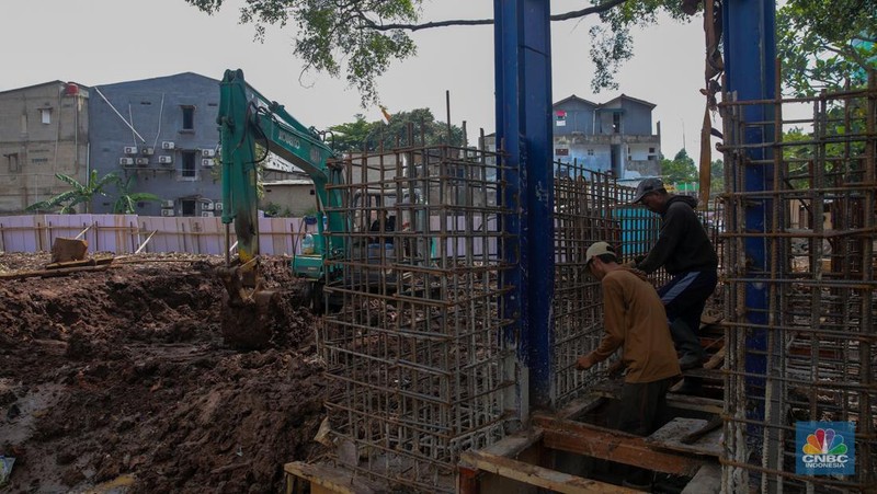 Pekerja mengerjakan proyek pembangunan tanggul dan pintu air Kali Krukut di kawasan Cilandak Timur, Jakarta, Rabu (19/11/2025).  (CNBC Indonesia/Faisal Rahman)