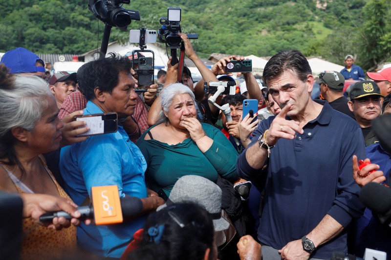 Seorang anak duduk di luar rumah yang rusak akibat tanah longsor setelah enam jam hujan deras yang menghancurkan rumah-rumah dan menyebabkan orang hilang, di Achira, Santa Cruz, Bolivia, 18 November 2025. (REUTERS/Ipa Ibanez)
