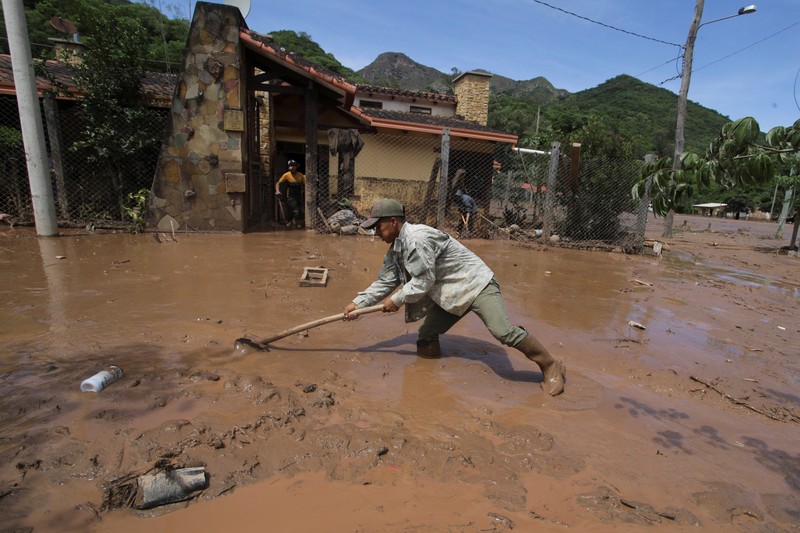 Seorang anak duduk di luar rumah yang rusak akibat tanah longsor setelah enam jam hujan deras yang menghancurkan rumah-rumah dan menyebabkan orang hilang, di Achira, Santa Cruz, Bolivia, 18 November 2025. (REUTERS/Ipa Ibanez)