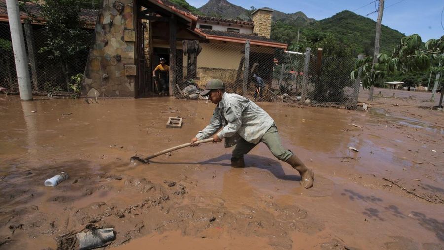 Seorang anak duduk di luar rumah yang rusak akibat tanah longsor setelah enam jam hujan deras yang menghancurkan rumah-rumah dan menyebabkan orang hilang, di Achira, Santa Cruz, Bolivia, 18 November 2025. (REUTERS/Ipa Ibanez)