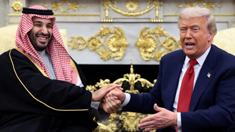 Saudi Crown Prince and Prime Minister Mohammed bin Salman laughs as U.S. President Donald Trump speaks while shaking hands during a meeting in the Oval Office at the White House in Washington, D.C., U.S., November 18, 2025.  REUTERS/Evelyn Hockstein