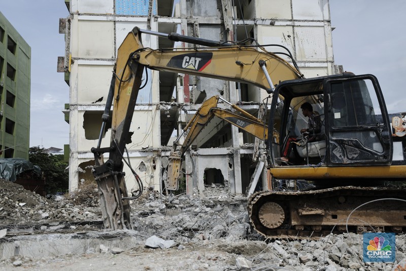 Pekerja menggunakan alat berat membongkar bangunan Rusunawa Marunda yang terbengkalai di Cilincing, Jakarta, Kamis (20/11/2025). (CNBC Indonesia/Tri Susilo)