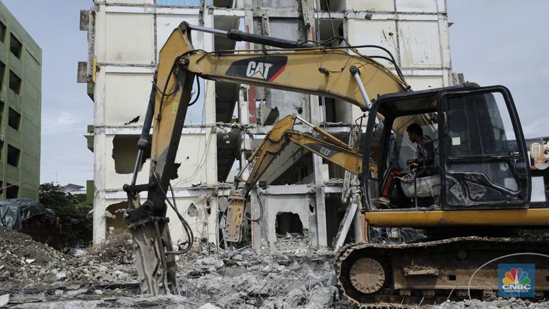 Pekerja menggunakan alat berat membongkar bangunan Rusunawa Marunda yang terbengkalai di Cilincing, Jakarta, Kamis (20/11/2025). (CNBC Indonesia/Tri Susilo)