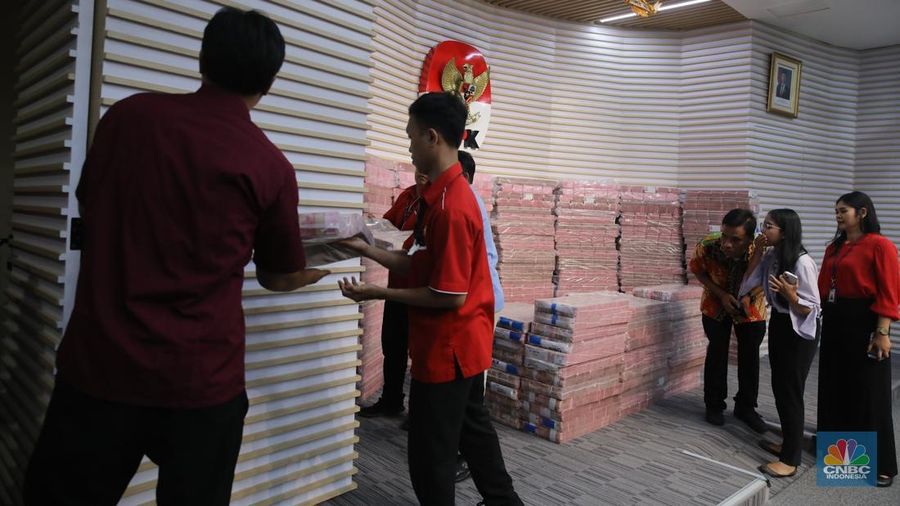 Petugss memindahkan uang di ruang konferensi pers Gedung  Merah Putih KPK, Jakarta, Kamis (20/11/2025). (CNBC Indonesia/Faisal Rahman)