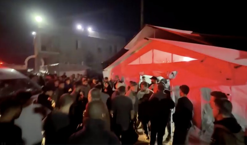 Seorang pria dan seorang anak berduka di dekat jenazah seorang warga Palestina yang tewas dalam serangan udara Israel, menurut petugas medis, di Rumah Sakit Al-Ahli Arab di Kota Gaza, 19 November 2025. REUTERS/Dawoud Abu Alkas