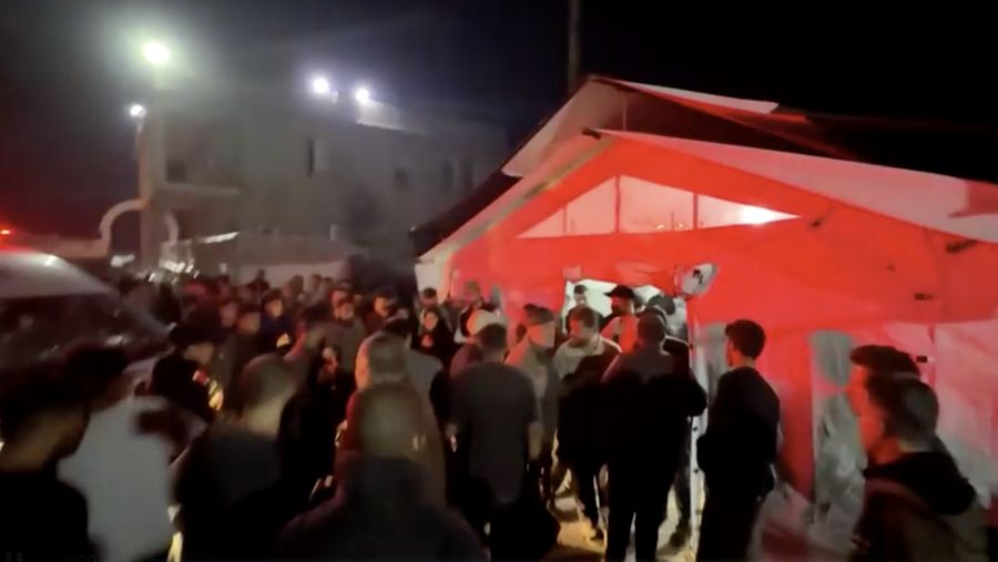 Seorang pria dan seorang anak berduka di dekat jenazah seorang warga Palestina yang tewas dalam serangan udara Israel, menurut petugas medis, di Rumah Sakit Al-Ahli Arab di Kota Gaza, 19 November 2025. REUTERS/Dawoud Abu Alkas