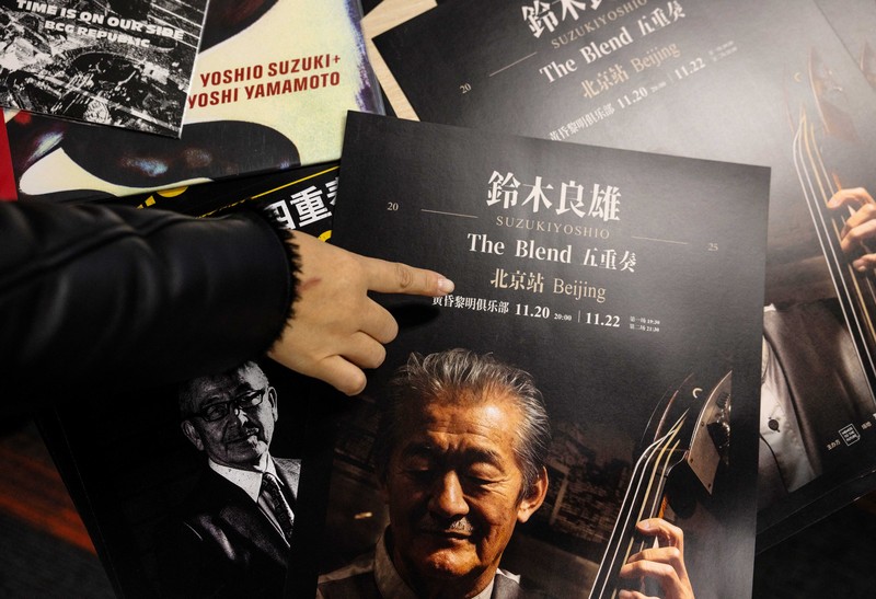 A man passes by the entrance to DDC music club featuring concert posters including Japanese musician Toshio Osumi in Beijing, China, November 21, 2025. REUTERS/Maxim Shemetov