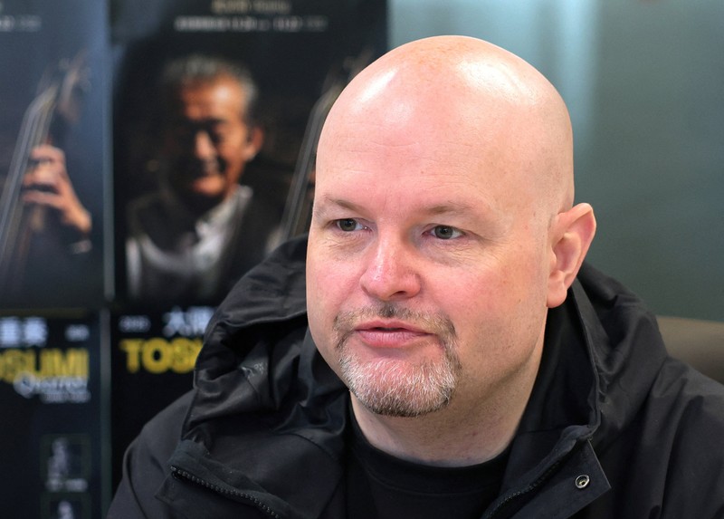 A man passes by the entrance to DDC music club featuring concert posters including Japanese musician Toshio Osumi in Beijing, China, November 21, 2025. REUTERS/Maxim Shemetov