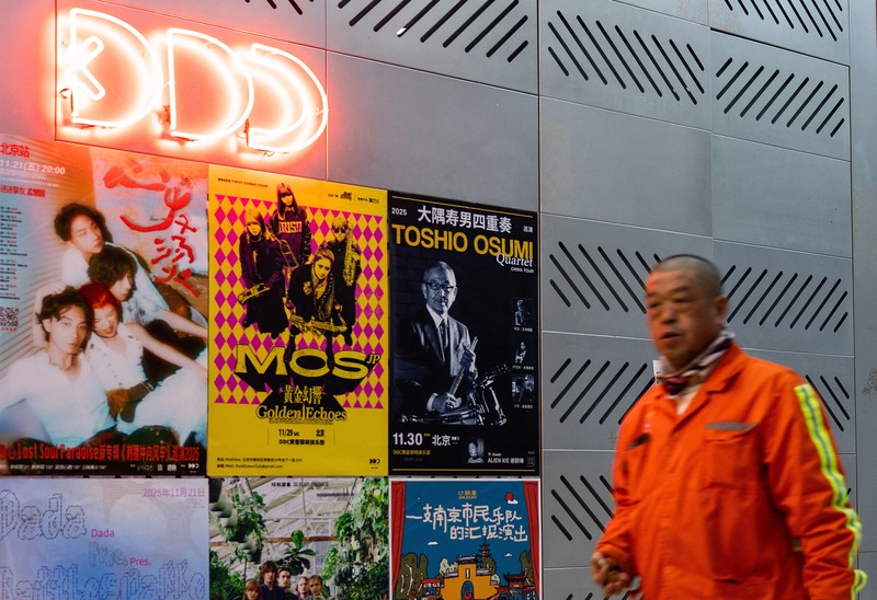 A man passes by the entrance to DDC music club featuring concert posters including Japanese musician Toshio Osumi in Beijing, China, November 21, 2025. REUTERS/Maxim Shemetov