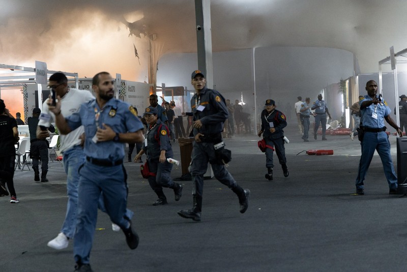 Orang-orang menggunakan alat pemadam kebakaran untuk memadamkan api di Paviliun Negara-negara di Zona Biru pada Konferensi Perubahan Iklim Perserikatan Bangsa-Bangsa (COP30) di Belem, Brasil, 20 November 2025. (REUTERS/Douglas Pingituro)