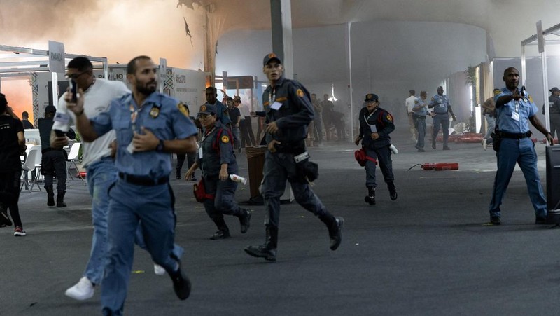 Orang-orang menggunakan alat pemadam kebakaran untuk memadamkan api di Paviliun Negara-negara di Zona Biru pada Konferensi Perubahan Iklim Perserikatan Bangsa-Bangsa (COP30) di Belem, Brasil, 20 November 2025. (REUTERS/Douglas Pingituro)
