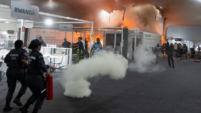 Orang-orang menggunakan alat pemadam kebakaran untuk memadamkan api di Paviliun Negara-negara di Zona Biru pada Konferensi Perubahan Iklim Perserikatan Bangsa-Bangsa (COP30) di Belem, Brasil, 20 November 2025. (REUTERS/Douglas Pingituro)