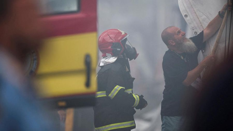 Orang-orang menggunakan alat pemadam kebakaran untuk memadamkan api di Paviliun Negara-negara di Zona Biru pada Konferensi Perubahan Iklim Perserikatan Bangsa-Bangsa (COP30) di Belem, Brasil, 20 November 2025. (REUTERS/Douglas Pingituro)