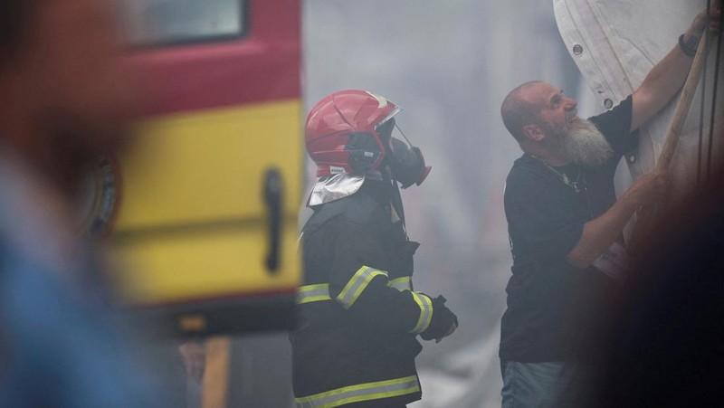 Orang-orang menggunakan alat pemadam kebakaran untuk memadamkan api di Paviliun Negara-negara di Zona Biru pada Konferensi Perubahan Iklim Perserikatan Bangsa-Bangsa (COP30) di Belem, Brasil, 20 November 2025. (REUTERS/Douglas Pingituro)