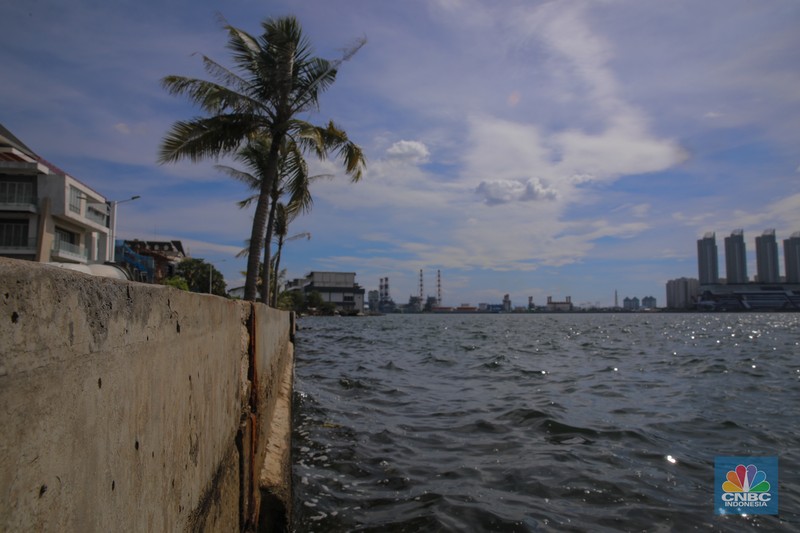 Pengendara sepeda motor melintas di samping tanggul Pantai Mutiara, Penjaringan, Jakarta Utara, Senin (24/11/2025). (CNBC Indonesia/Faisal Rahman)